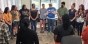 A group of adults standing a circle while having a discussion.