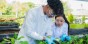 Two high school students wearing lab coats in a plant nursery.