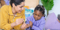 A teacher assists a preschool student with flash cards.